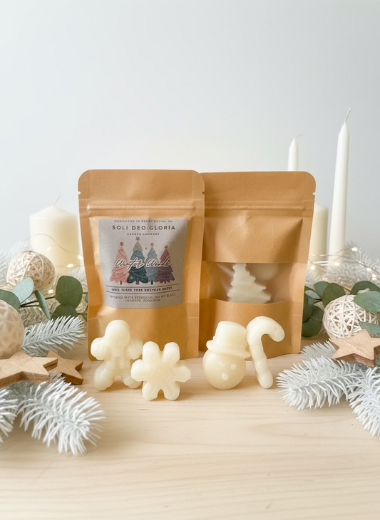 Scented wax melts in packaging on a kitchen counter with 'Soli Deo Gloria' branding.